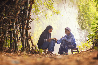 Young couple sitting on tree