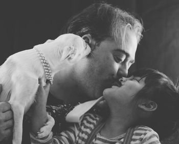 Father and daughter embracing while holding dog