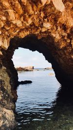 Scenic view of sea seen through cave