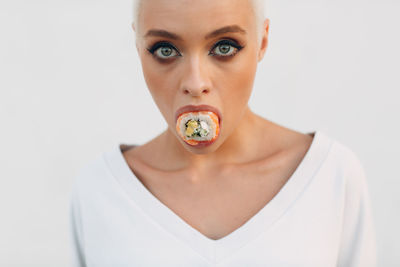 Portrait of young woman against white background