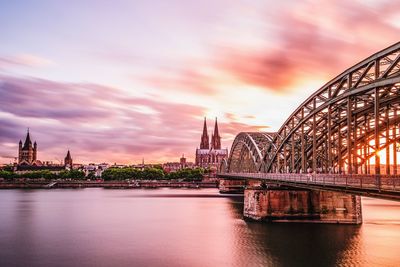 Bridge over river against cloudy sky