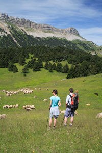 People on field against mountain range