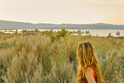 Young woman looking to mono lake during sunset in northen california