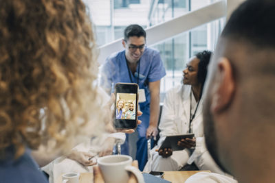 Female nurse taking selfie with colleague through smart phone during coffee break in hospital