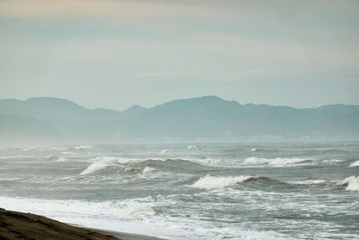 Scenic view of sea and mountains against sky