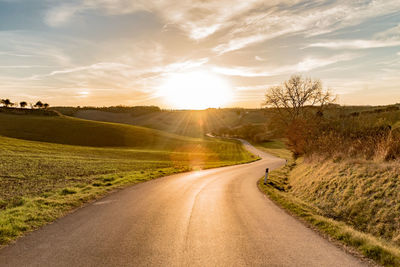 Road on landscape against sky during sunset