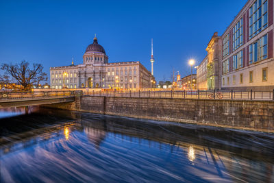 The reconstructed berlin palace with the television tower at the blue hour