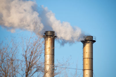 Smoke emitting from chimney against sky