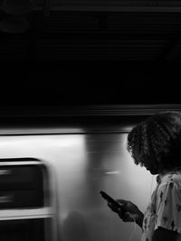 Blurred motion of woman standing at railroad station