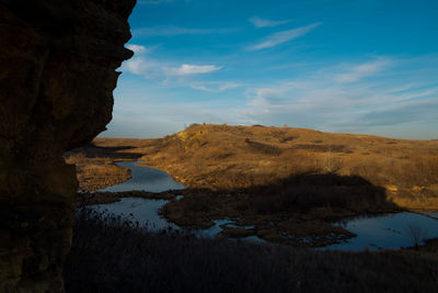 Scenic view of rock formations by lake against sky