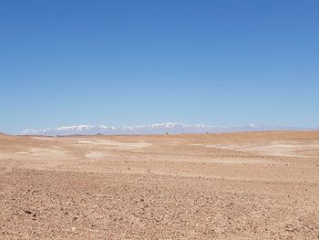 Scenic view of desert against clear blue sky