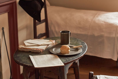 High angle view of coffee with bread by book on table