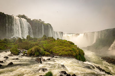 Scenic view of waterfall against sky