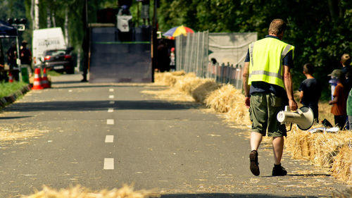 Rear view of woman walking on road