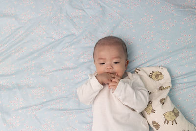 Cute baby girl lying on bed