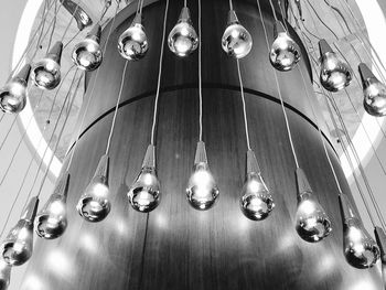 Low angle view of illuminated light bulbs hanging from ceiling