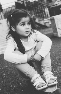 Portrait of cute girl sitting outdoors