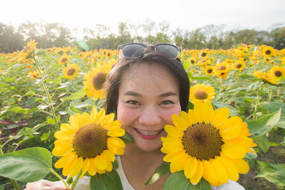 Portrait of smiling woman with yellow sunflower