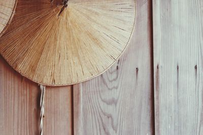 Close-up of asian style conical hat on wooden wall