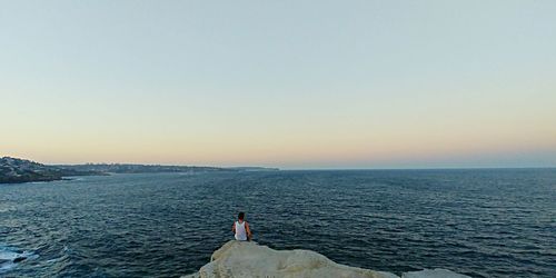 Man looking at sea against clear sky