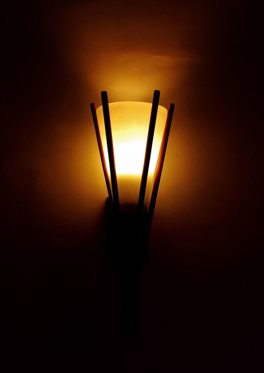 CLOSE-UP OF ILLUMINATED LAMP AGAINST WALL