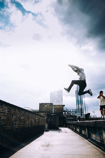 MAN WITH UMBRELLA AGAINST SKY