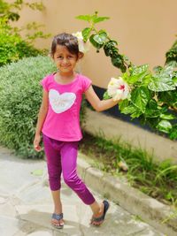 Cute girl in the yard with beautiful flowers