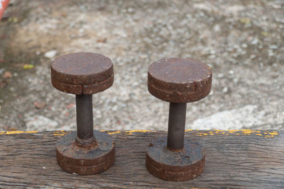 Close-up of rusty metal on wood against wall