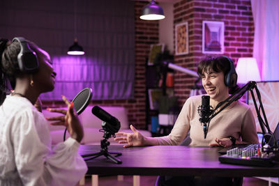 Portrait of young woman using mobile phone while sitting at restaurant