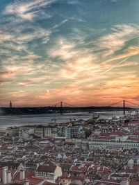 Aerial view of town by sea against sky during sunset