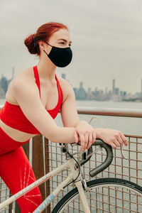 Full length of woman looking at railing against sky