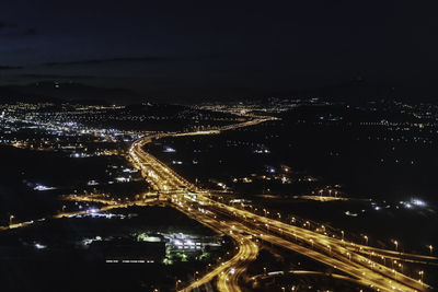 High angle view of illuminated cityscape against sky at night