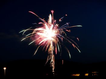 Low angle view of firework display at night