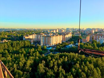 High angle view of trees and buildings against blue sky