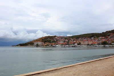 Scenic view of sea by city against sky