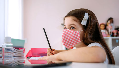 Portrait of girl sitting on table