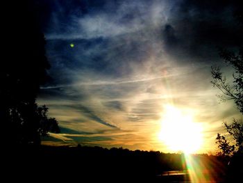 Silhouette trees against scenic sky