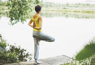 Young smiling woman practice yoga outdoors. new normal social distance. physical and mental health