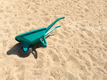 Green toy on sand at beach