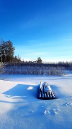 Snow on field against blue sky during winter