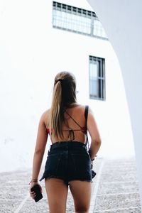 Rear view of woman standing against building