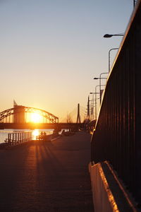 Bridge over river against sky during sunset