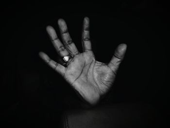 Cropped image of hand over black background