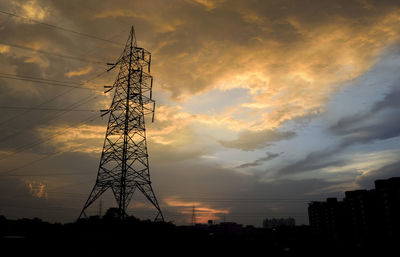 Low angle view of silhouette electricity pylon against sky during sunset