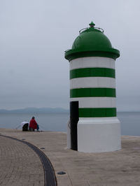 Rear view of lighthouse on sea against sky