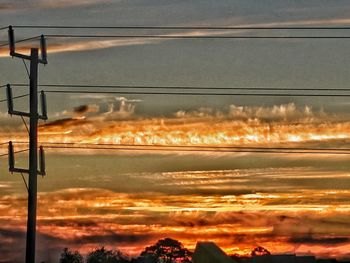 Silhouette of electricity pylon at sunset