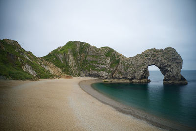 Rock formations by sea against sky