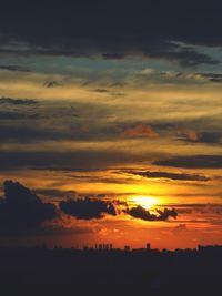 Silhouette buildings against sky during sunset