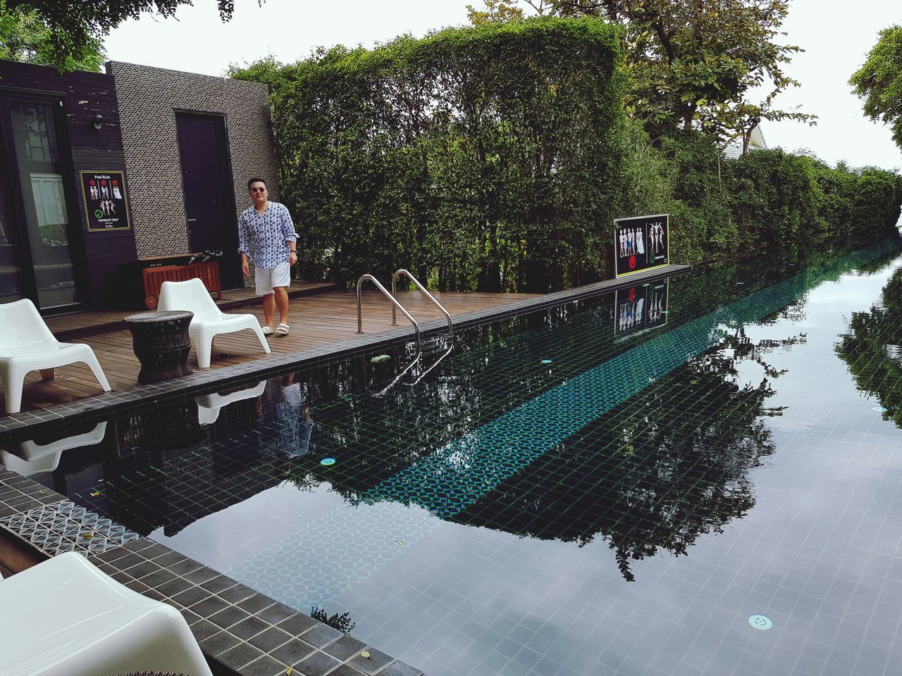 water, pool, swimming pool, one person, real people, full length, nature, lifestyles, tree, plant, leisure activity, day, poolside, standing, reflection, young adult, outdoors, adult