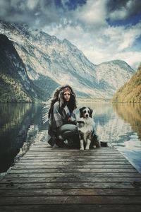 Woman with dog on pier over lake